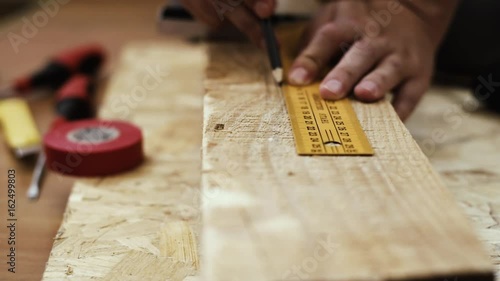 Craftsman working with wood with construction tools on the floor in studio.  