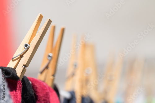 Close up of clothing pegs holding washing on the washline. photo