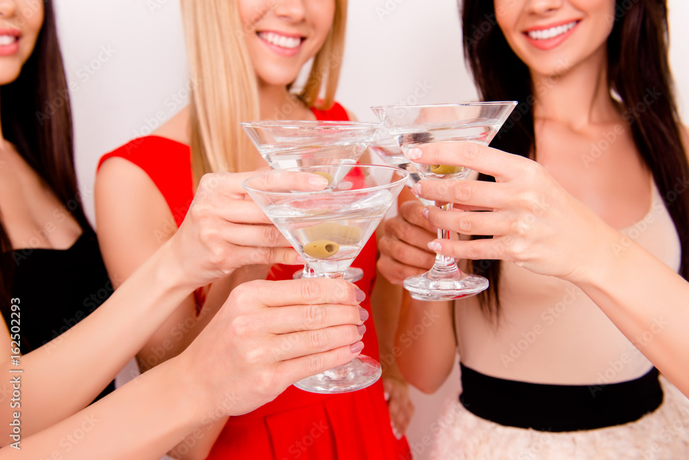 Party all night long! Cropped closeup of young festive fancy ladies clinking the glasses and toasting for the birthday girl, all in colorful outfits, smiling, laughing, enjoying themselves Party all night long! Cropped closeup of young festive fancy ladies clinking the glasses and toasting for the birthday girl, all in colorful outfits, smiling, laughing, enjoying themselves