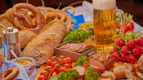 Bayrischer Imbiss mit Fleischkäse Bier Brezen Brot rustikal
