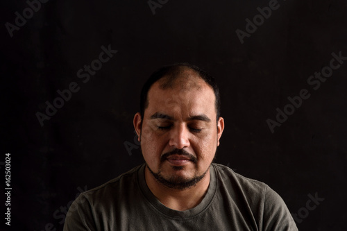 Portrait of a latin man on black background © curto