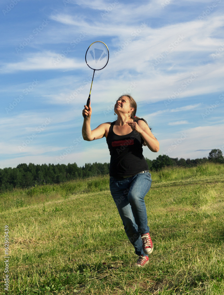 Young woman playing badminton.