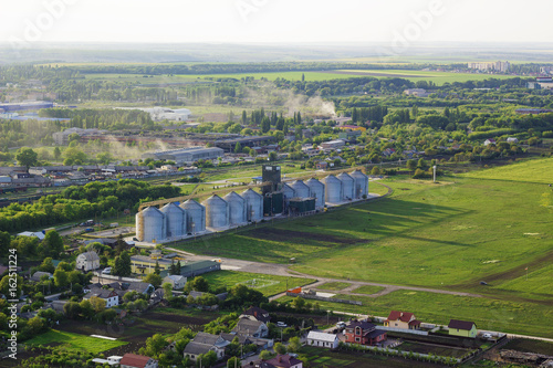 Aerial view of сompound feed plant, factories, fields and houses of industrial city