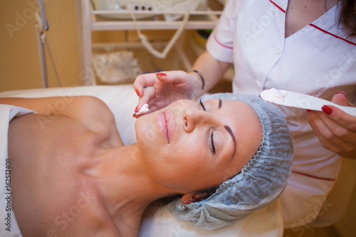 Cosmetology doctor makes woman treatments facial massage photo