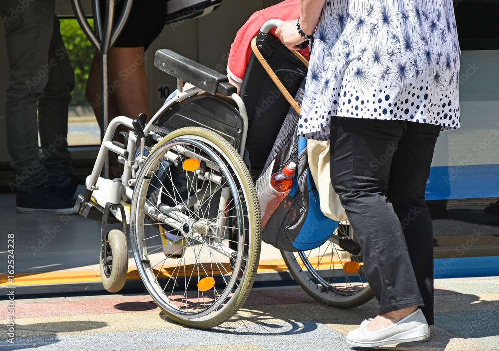 Man in wheelchair gets in to tram