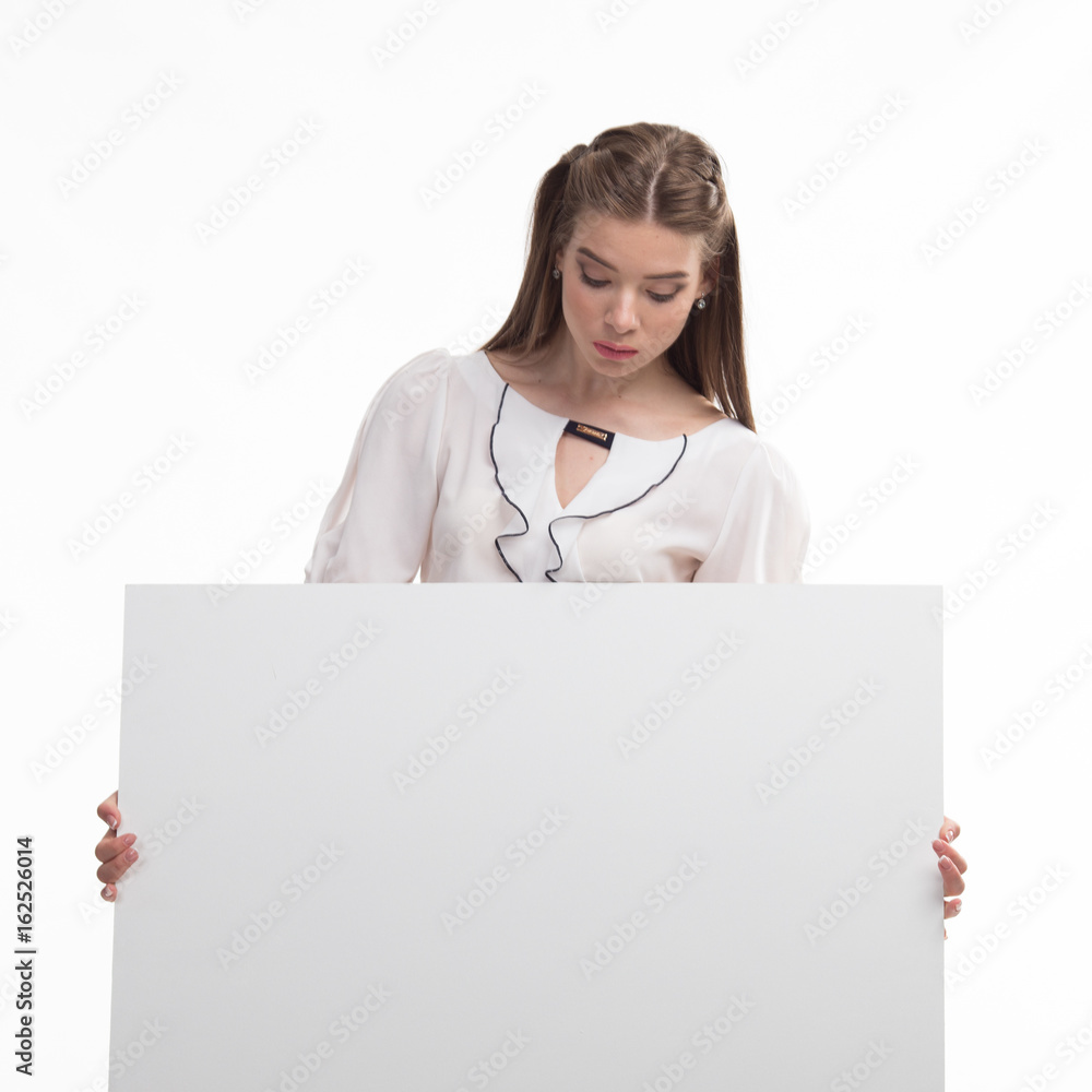 Young curious woman portrait of a confident businesswoman showing presentation, pointing placard gray background. Ideal for banners, registration forms, presentation, landings, presenting concept.. Young curious woman portrait of a confident businesswoman showing presentation, pointing placard gray background. Ideal for banners, registration forms, presentation, landings, presenting concept..
