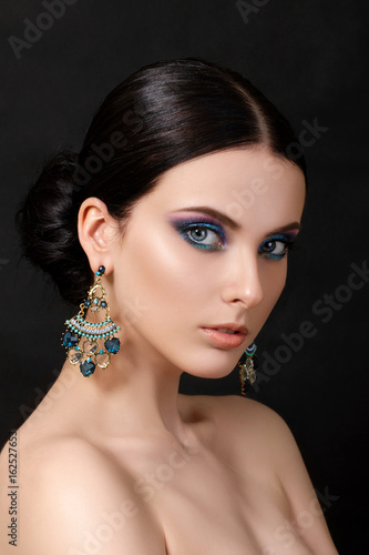 Portrait of beautiful brunet woman with blue earrings