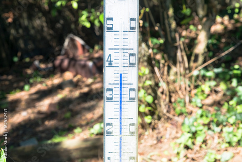 Ein Überdimensionales Quecksilber Thermometer im Garten steht in praller Sonne
