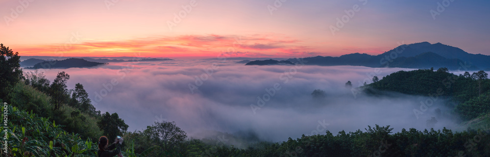 Landscape misty panorama. Fantastic dreamy sunrise on the mountains with a beautiful view. Foggy clouds above the landscape.