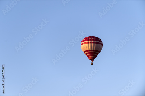 ein heißluftballon in rot und gelb vor blauem Himmel © bevisphoto