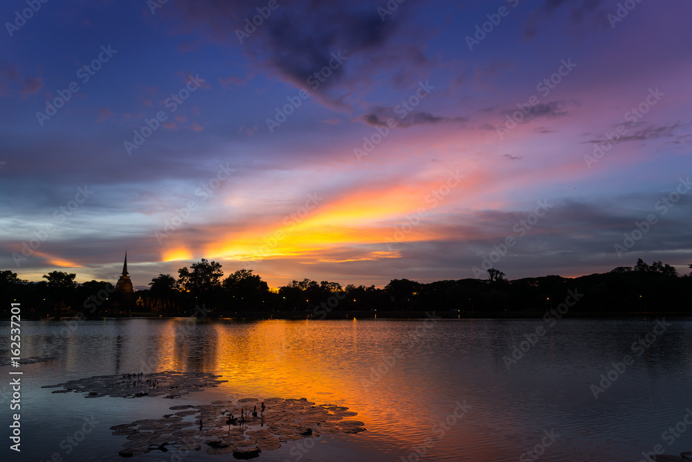 Silhouette Sunset / Sun Rise  Sky and reflection on water at Sukhothai Historical Park of Sukhothai city, Thailand