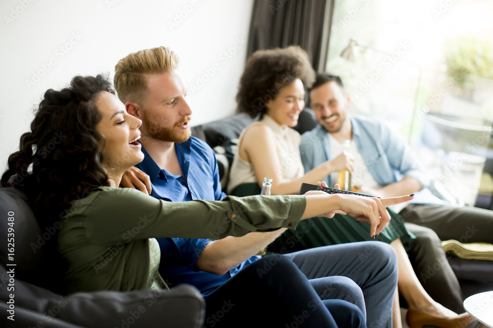 Group of friends watching TV, drinking cider and having fun Group of friends watching TV, drinking cider and having fun