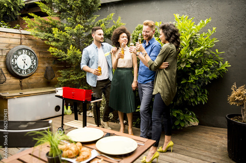 Friends grilling food and e...