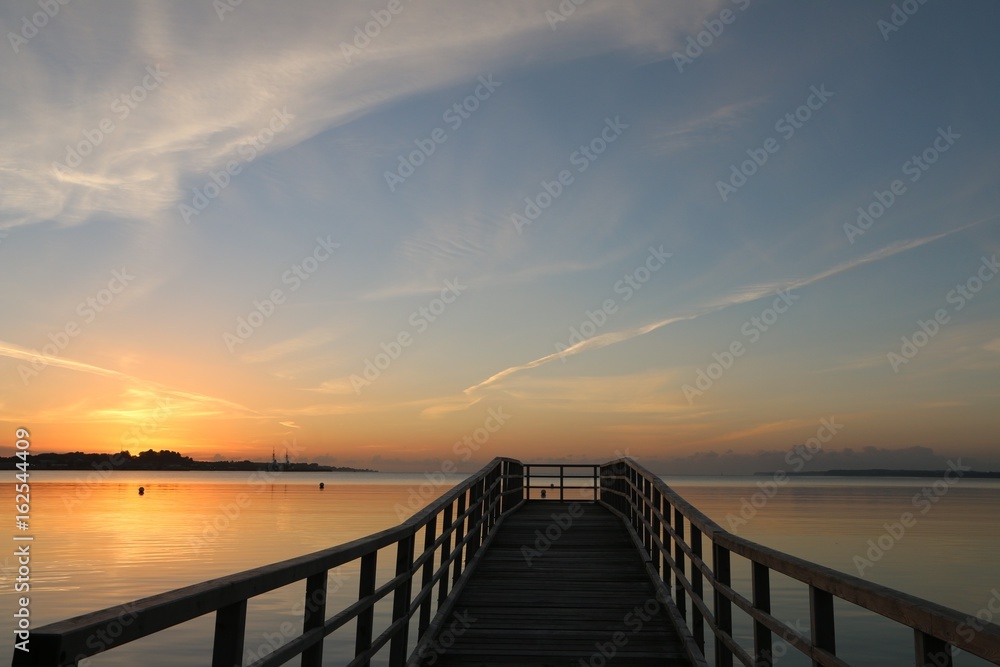 malerischer Sonnenaufgang an einer Seebrücke an der Ostsee, Schleswig-Holstein, Deutschland 