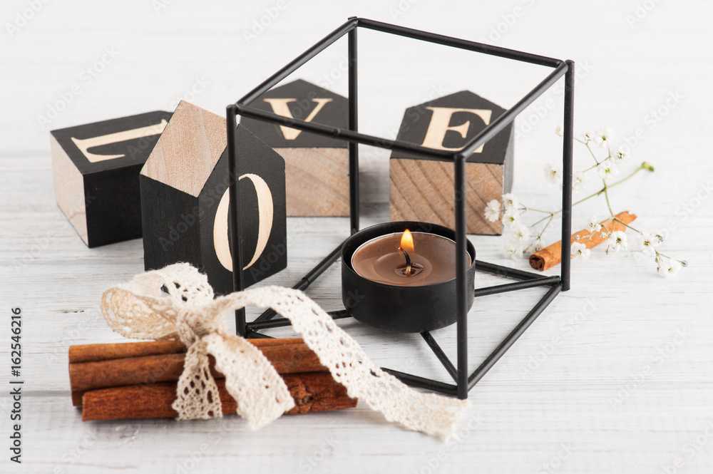Flowers and lit candle, wooden letter Love