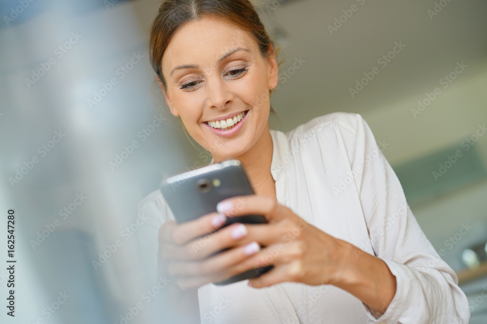 Cheerful woman sending message with smartphone Cheerful woman sending message with smartphone
