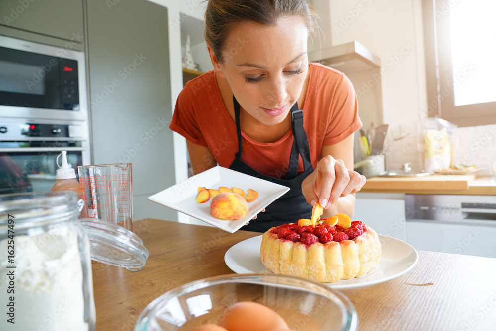 Young woman in modern kitchen baking raspberry cake Young woman in modern kitchen baking raspberry cake
