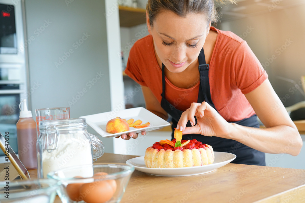Young woman in modern kitchen baking raspberry cake Young woman in modern kitchen baking raspberry cake