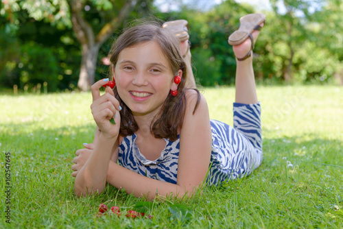 pretty teenage girl outdoors with cherry