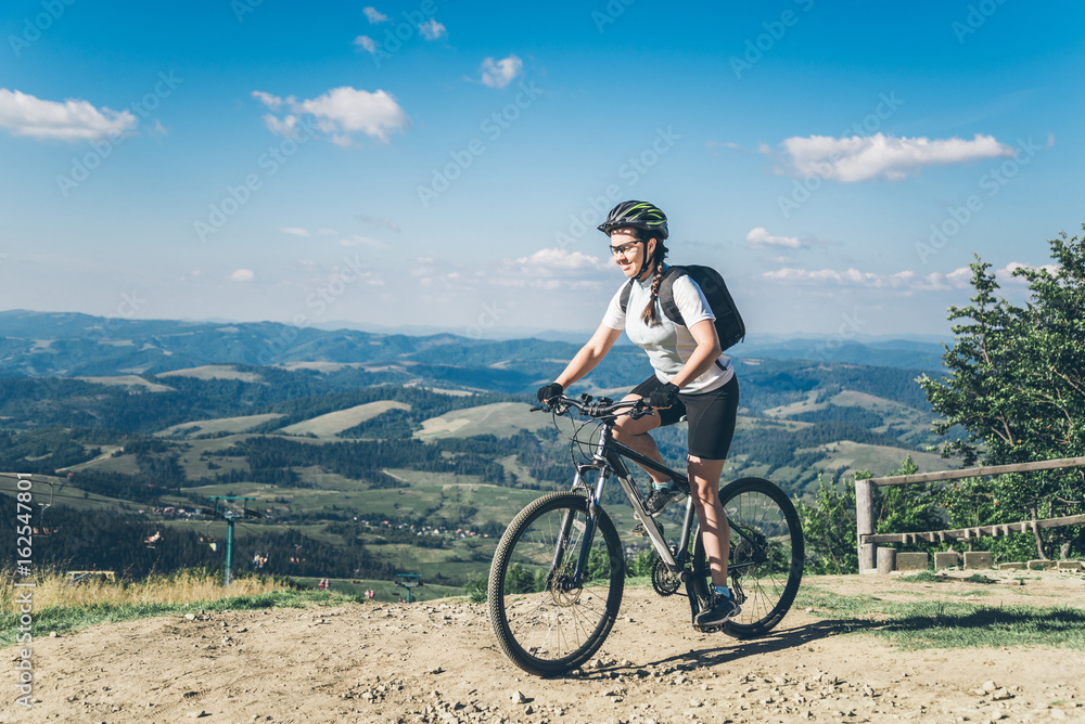 Young woman riding on MTB in mountains Young woman riding on MTB in mountains