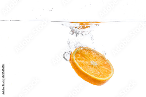orange slice in water splash on white background