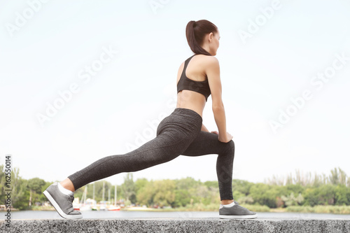 Pretty young woman stretching outdoors