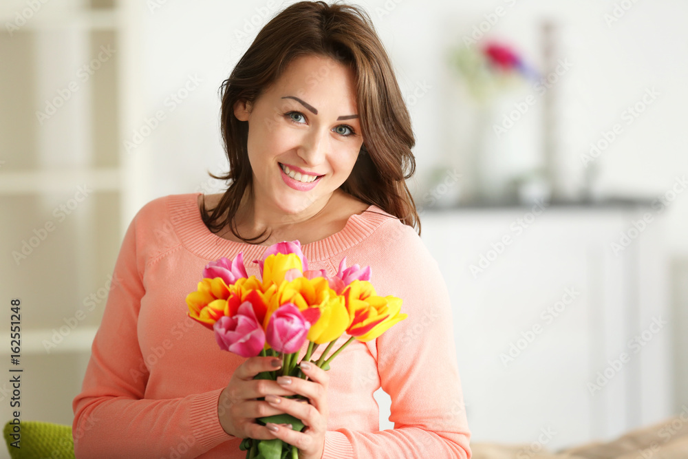 Beautiful woman holding bouquet of tulips on blurred background Beautiful woman holding bouquet of tulips on blurred background