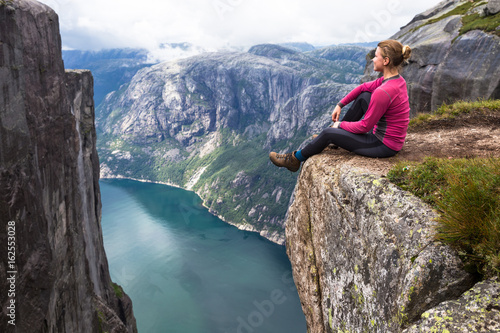 Happy people relax in cliff during trip Norway. hiking route