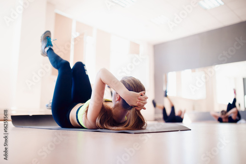 girl is rocking the press on a group session with fitness and yoga, the concept of weight loss before the summer.