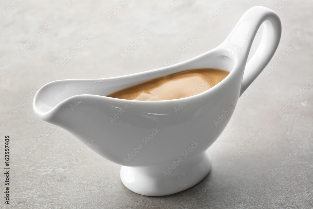 Sauce boat with turkey gravy on light background Sauce boat with turkey gravy on light background