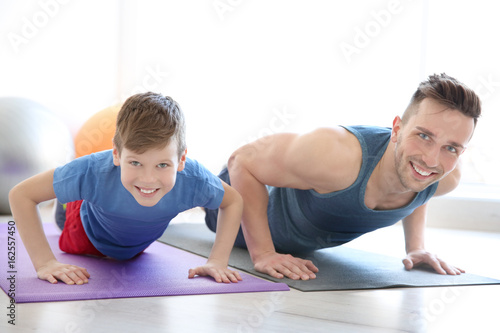 Dad and son doing push-ups in gym