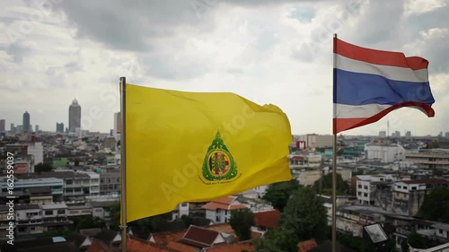 Yellow flag on the top of Wat Saket (Golden Mountain). Bangkok panorama view on background. Thailand. photo