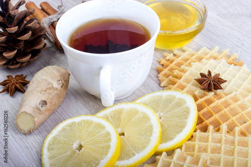 Cup of tea with honey, pinecone, badian, ginger, waffles and cinnamon