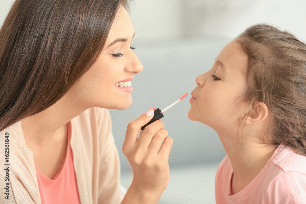 Young woman making up her daughter at home Young woman making up her daughter at home