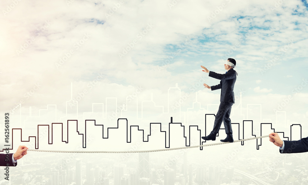 Business concept of risk support and assistance with man balancing on rope Business concept of risk support and assistance with man balancing on rope
