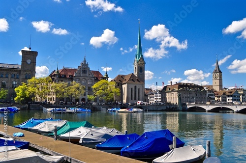 Wahrzeichen von der Stadt Zürich: die Kirche Fraumünster und St. Peter. Im Vordergrund Boote im Hafen vom Fluss Limmat