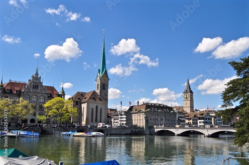 Historische Altstadt von Zürich am Wasser mit St. Peter Kirche, Fraumünster, Rathausbrücke, Fluss Limmat und blauem Himmel