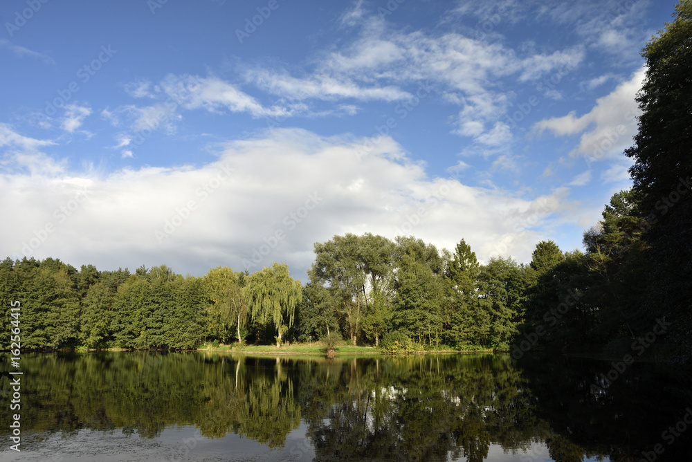 Wolkenverhangener See mit Regenbogen, cloudy lake with strong rainbow