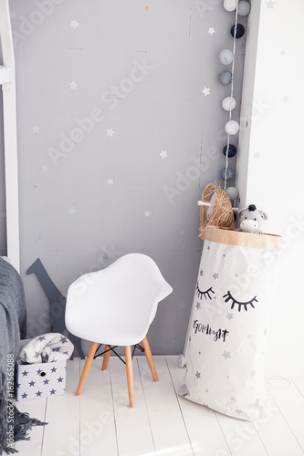 Toddler room with white cradle, chair and storage bag