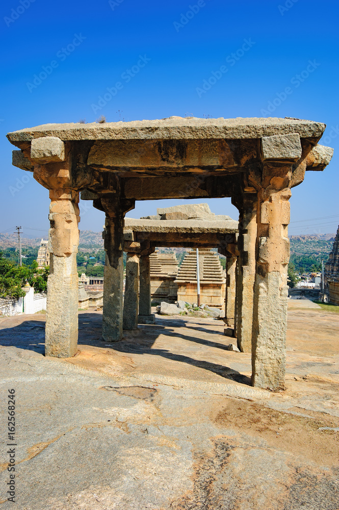 View of ancient ruins on Hemakuta hill in Hampi, Karnataka, India. Landscape with unique mountain formation with amazing stones, tropical nature and temple. UNESCO World Heritage Site