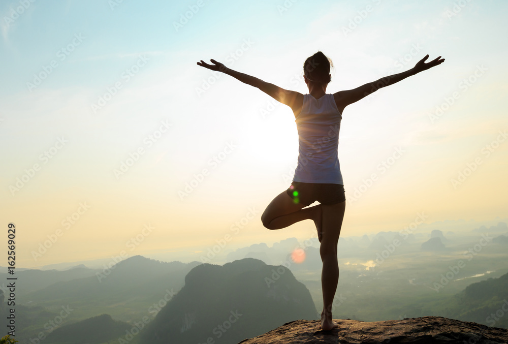 young fitness woman meditating on sunrise mountain peak young fitness woman meditating on sunrise mountain peak
