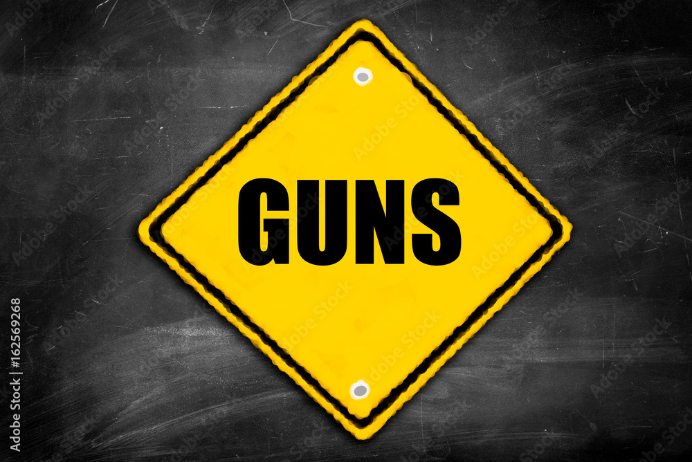 guns written on caution sign guns written on caution sign