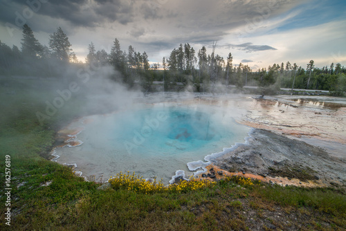 Volcanic Hot Spring on Fountain Paint Pot Nature Trail with Hot Blue Water and Wildflowers During Sunset in Yellowstone National Park