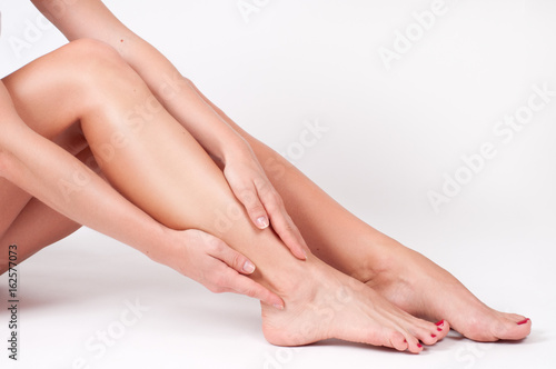 Ankle pain. Female legs. Woman massaging her ankle