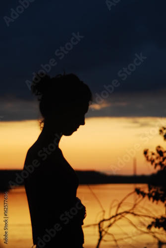 Girl silhouette by the river