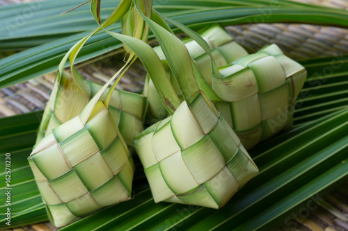 Ketupat, Kupat or Tipat is a type of dumpling made from rice packed inside a diamond-shaped container of woven palm leaf pouch. It is commonly found in Indonesia, Malaysia, Brunei and Singapore. photo