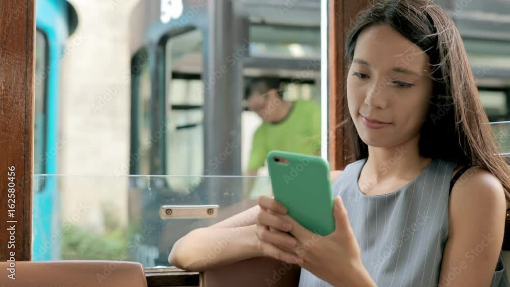 Hong Kong island, Hong Kong, 06 June 2017 -: Woman taking tram and use of cellphone Hong Kong island, Hong Kong, 06 June 2017 -: Woman taking tram and use of cellphone
