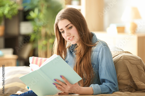 Beautiful woman reading book at home