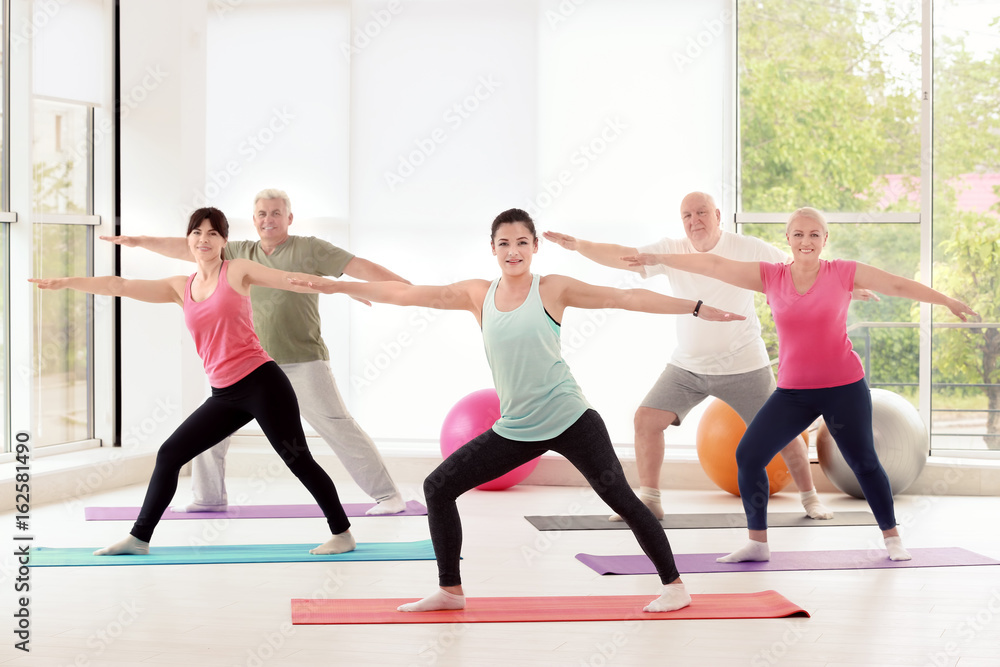 Obraz premium Group of people practicing yoga in gym