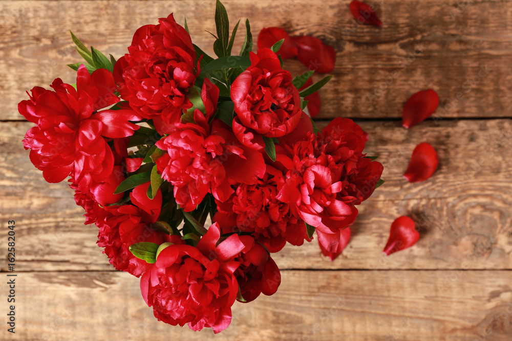 Top view of beautiful peonies on wooden table